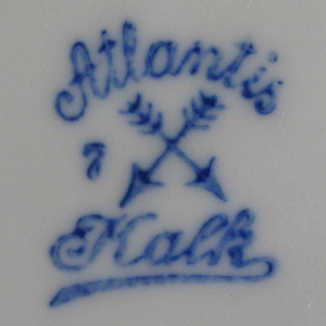 rechtwinkelig gekreuzte Pfeile mit Spitzen nach unten und Schriftzug Atlantis darüber und Kalk darunter, unterglasur